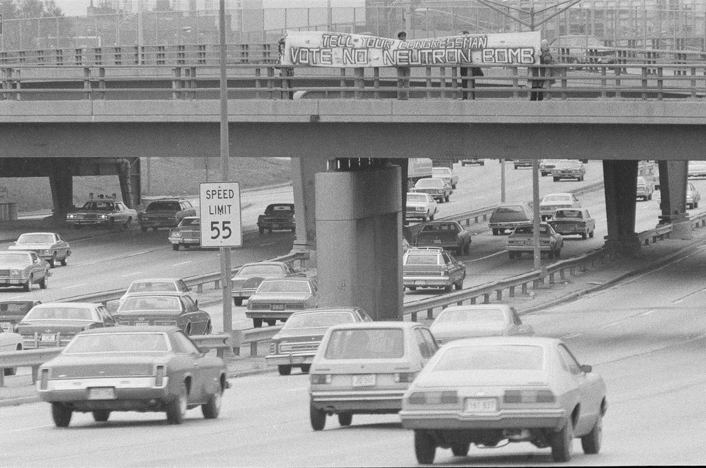 Protesters against the production of the Neutron Bomb hold a banner above the expressway - Chicago Sun-Times