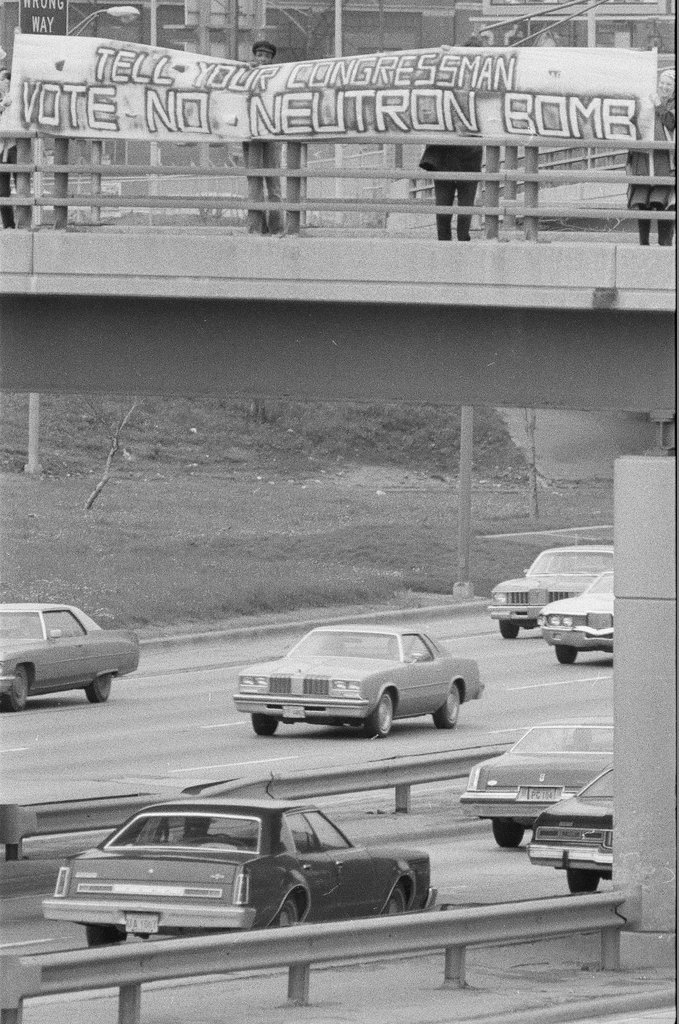 Protesters against the production of the Neutron Bomb hold a banner above the expressway - Chicago Sun-Times