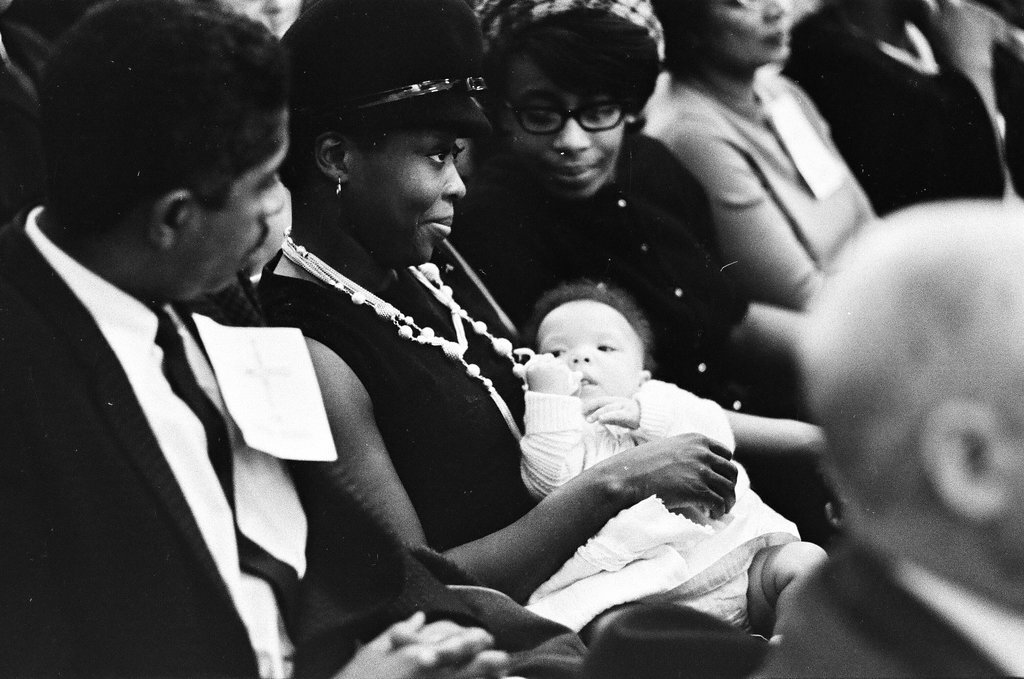 Woman holding a baby at a busing community meeting - Chicago Sun-Times