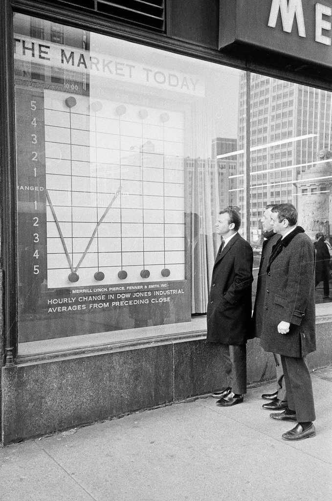 Pedestrians check stock market in sidewalk window - Elliott Robinson for Chicago Sun-Times