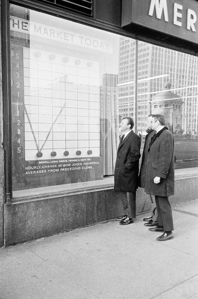 Pedestrians check stock market in sidewalk window - Elliott Robinson for Chicago Sun-Times