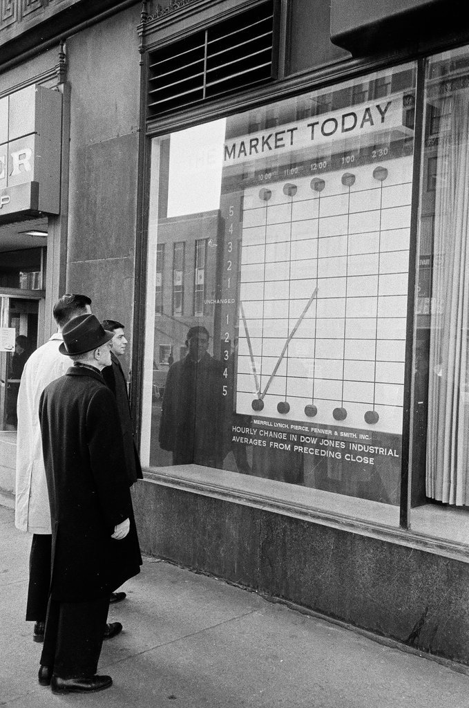 Pedestrians check stock market in sidewalk window - Elliott Robinson for Chicago Sun-Times