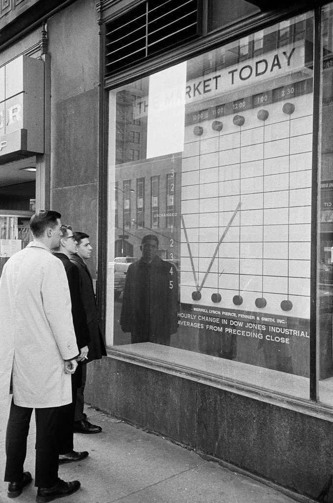 Pedestrians check stock market in sidewalk window - Elliott Robinson for Chicago Sun-Times