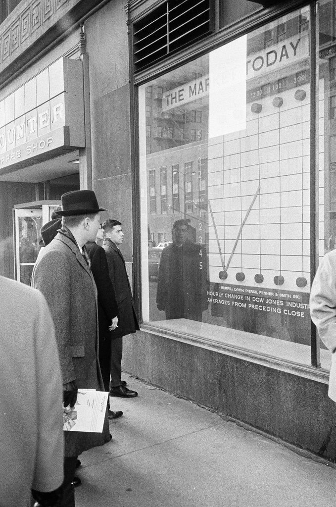 Pedestrians check stock market in sidewalk window - Elliott Robinson for Chicago Sun-Times