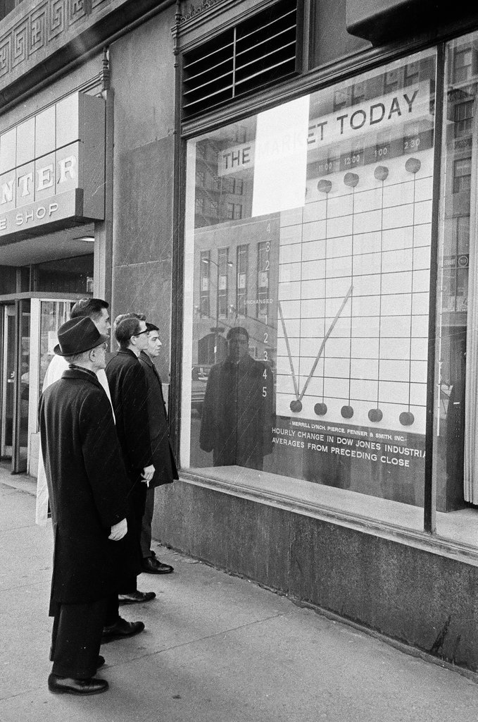 Pedestrians check stock market in sidewalk window - Elliott Robinson for Chicago Sun-Times