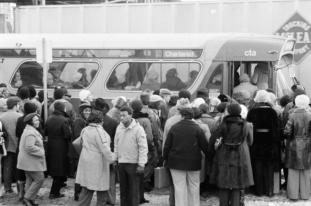 People waiting to board busses - Chicago Sun-Times