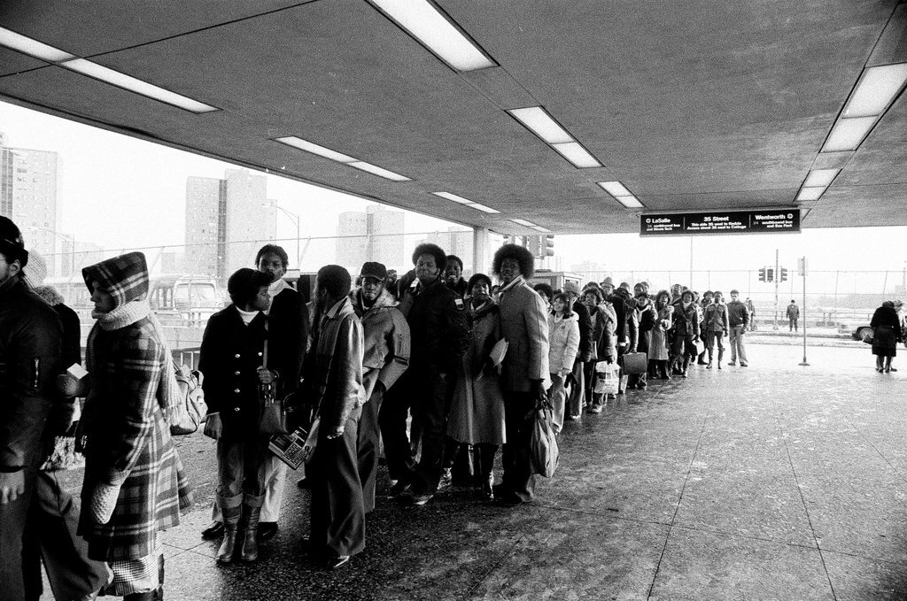 People waiting to board busses - Chicago Sun-Times