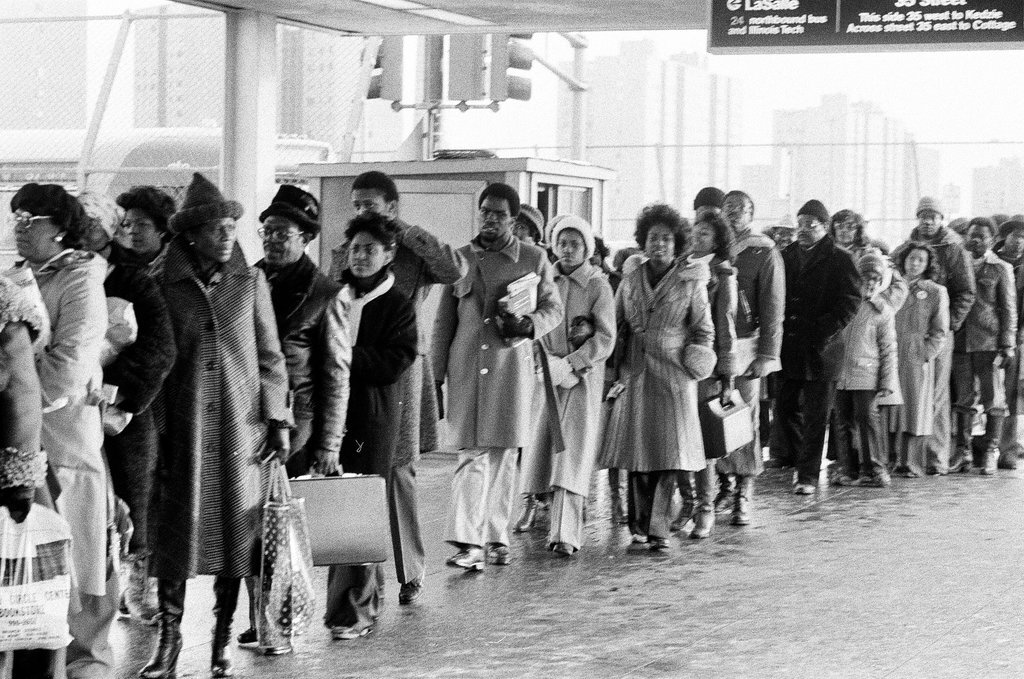 People waiting to board busses - Chicago Sun-Times