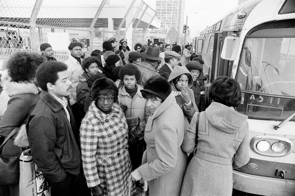 People waiting to board busses - Chicago Sun-Times