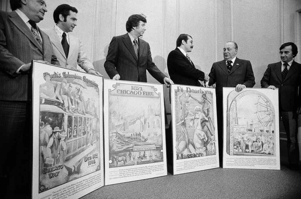 Men pose with posters of historical events - Chicago Sun-Times