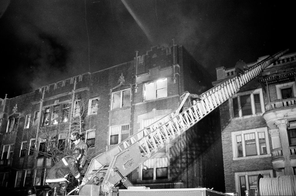Firefighters using hoses on apartment building - Chicago Sun-Times