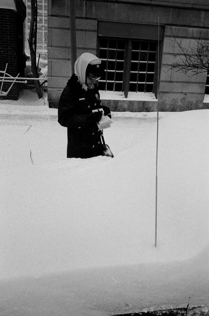 Meter maid placing ticket on snow-covered car - Chicago Sun-Times