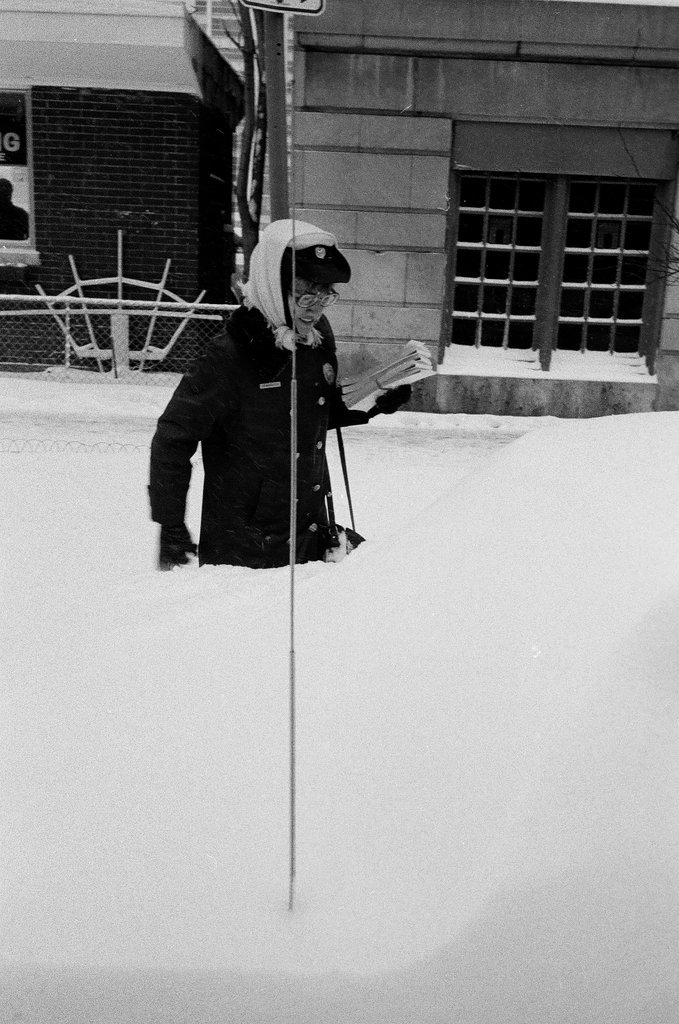 Meter maid placing ticket on snow-covered car - Chicago Sun-Times