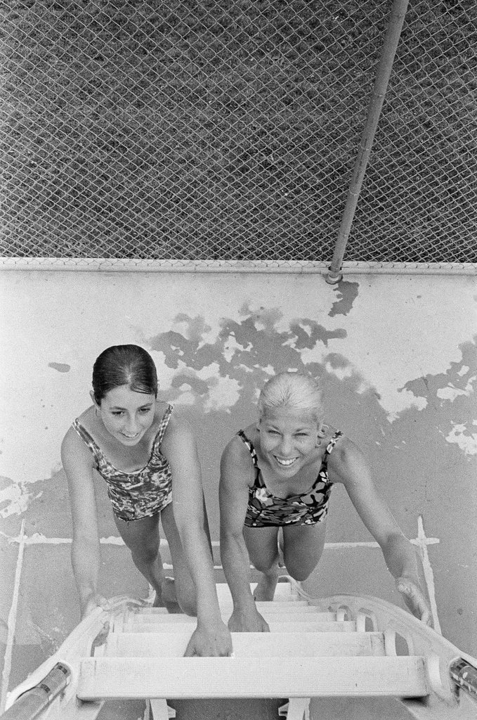 Two women pose on diving platform ladder - Chicago Sun-Times