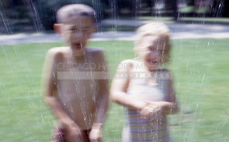 Boy and a girl in a sprinkler - Maier, Vivian