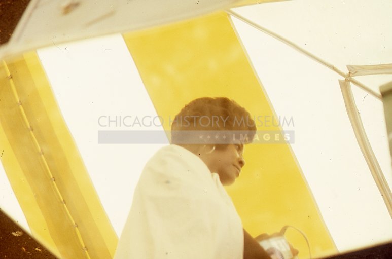 Woman in a yellow and white tent at rummage sale at Kenilworth Union Church - Maier, Vivian