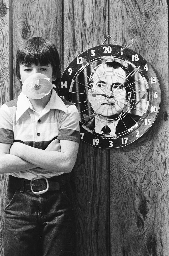 Boy throws darts at Richard Nixon dart board - Gene Pesek for Chicago Sun-Times