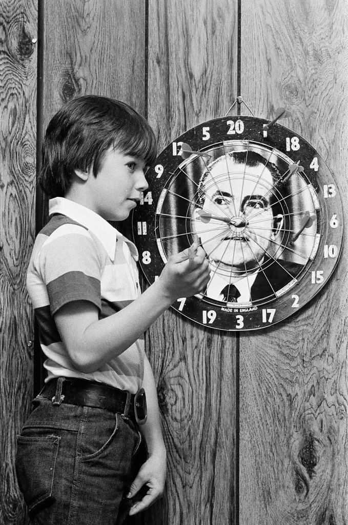 Boy throws darts at Richard Nixon dart board - Gene Pesek for Chicago Sun-Times