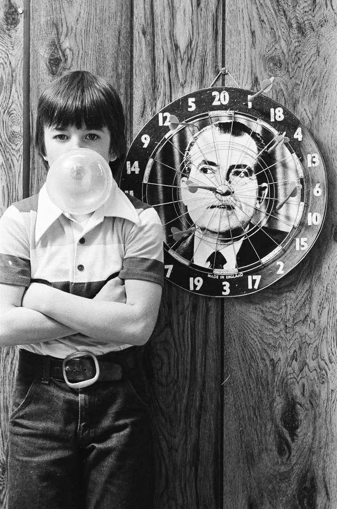 Boy throws darts at Richard Nixon dart board - Gene Pesek for Chicago Sun-Times