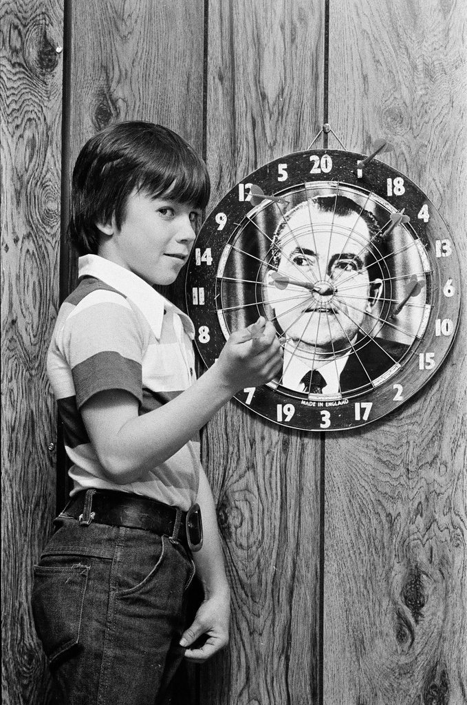 Boy throws darts at Richard Nixon dart board - Gene Pesek for Chicago Sun-Times