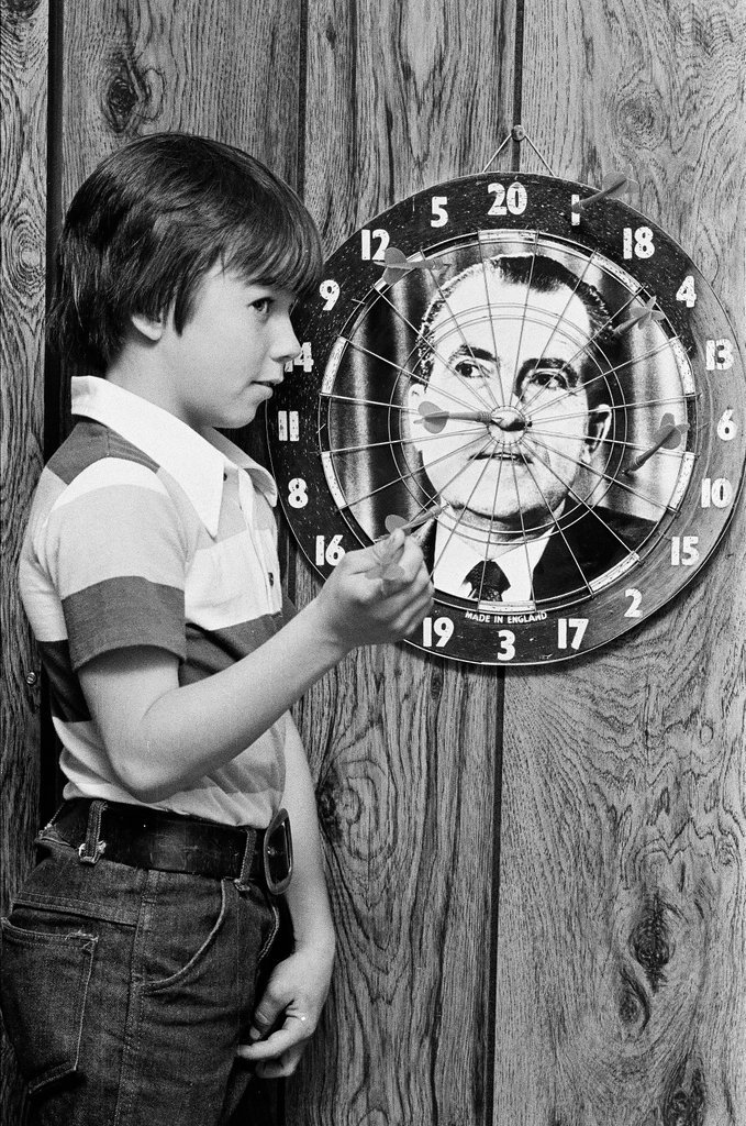 Boy throws darts at Richard Nixon dart board - Gene Pesek for Chicago Sun-Times