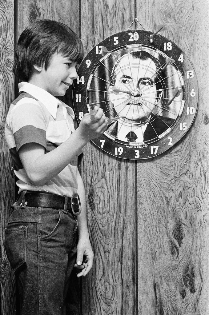 Boy throws darts at Richard Nixon dart board - Gene Pesek for Chicago Sun-Times