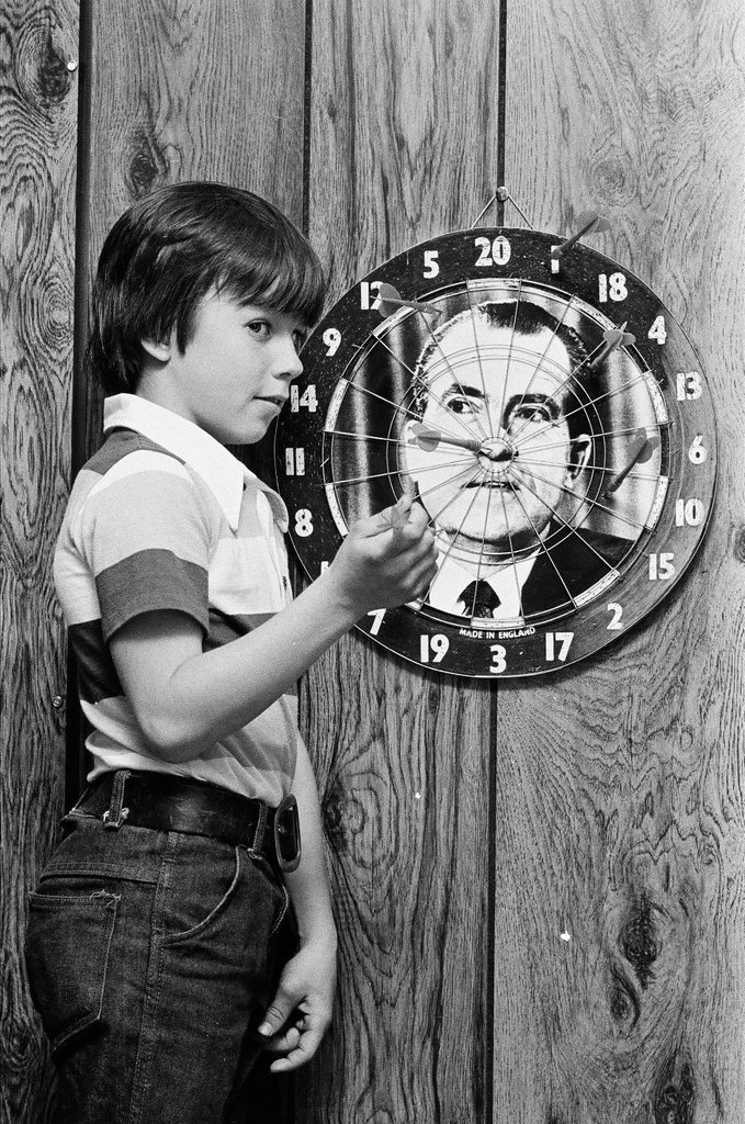Boy throws darts at Richard Nixon dart board - Gene Pesek for Chicago Sun-Times