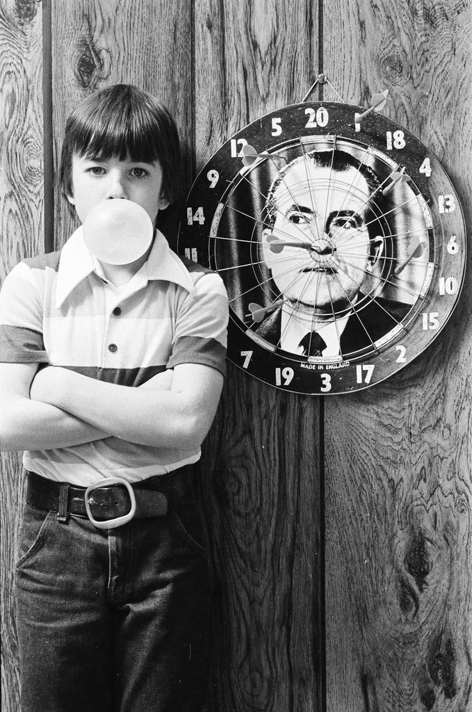 Boy throws darts at Richard Nixon dart board - Gene Pesek for Chicago Sun-Times