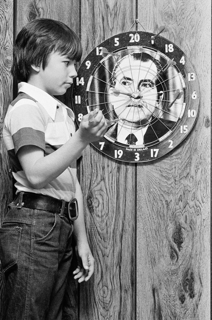 Boy throws darts at Richard Nixon dart board - Gene Pesek for Chicago Sun-Times