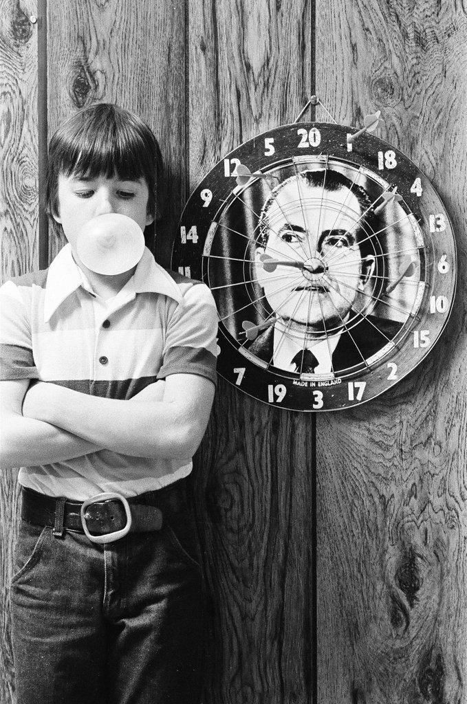 Boy throws darts at Richard Nixon dart board - Gene Pesek for Chicago Sun-Times