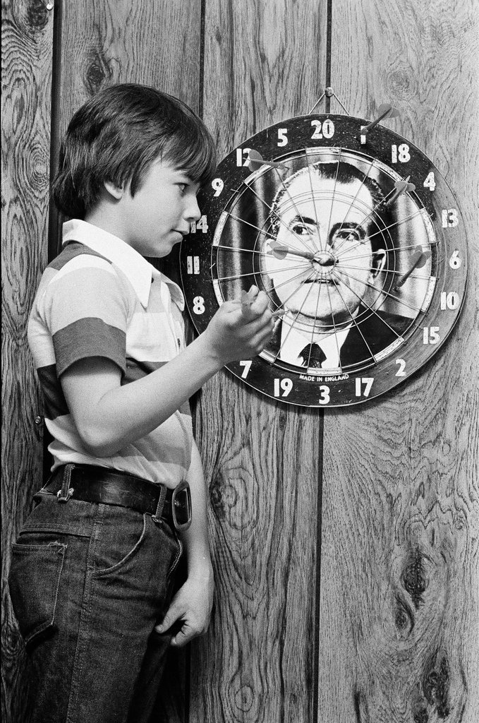 Boy throws darts at Richard Nixon dart board - Gene Pesek for Chicago Sun-Times