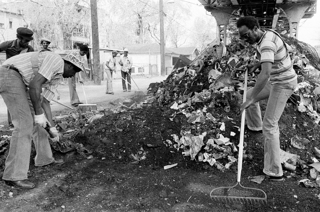 City sanitation workers clear garbage under 