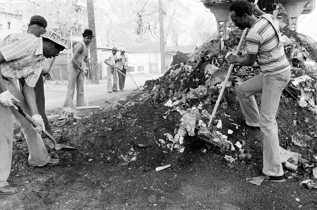 City sanitation workers clear garbage under 