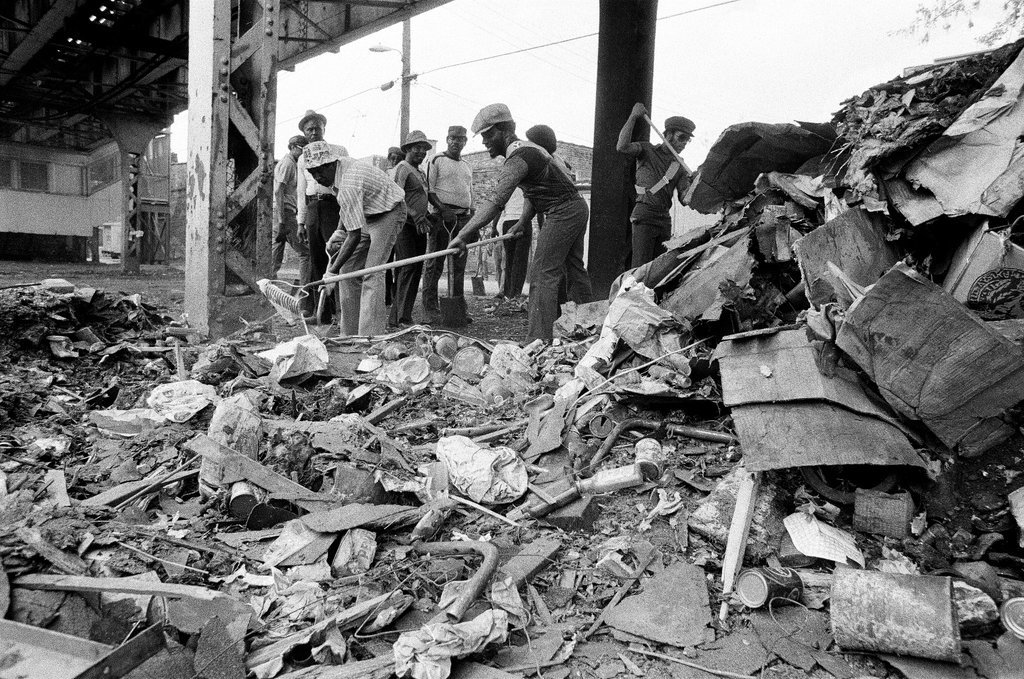 City sanitation workers clear garbage under 