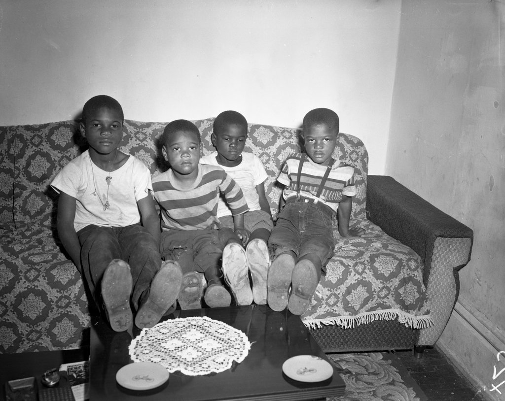 Children show off worn shoes in Kenwood apartment - Chicago Sun-Times