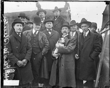 Captain George Wellington Streeter holding dog, standing with group of unidentified men - Chicago Daily News, Inc.