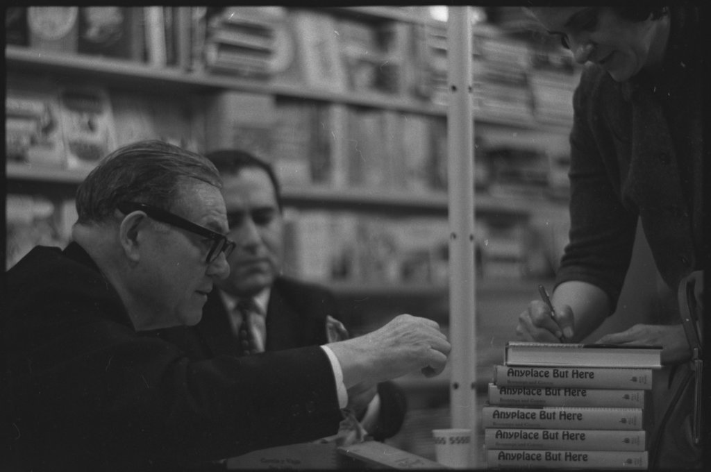 Writer Jack Conroy signing copies of 'Anyplace But Here' - Flerlage, Raeburn, 1915-2002
