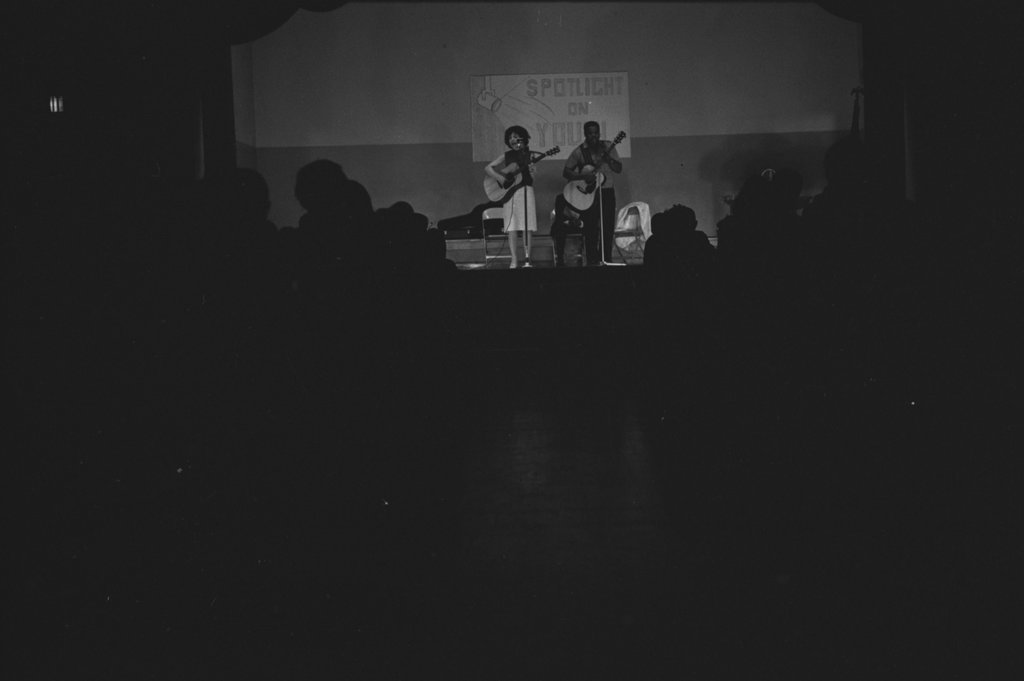 Folk singers performing in a school auditorium - Flerlage, Raeburn, 1915-2002