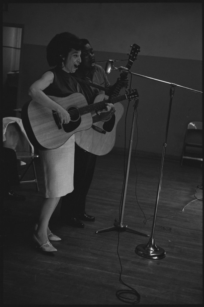 Folk singers performing in a school auditorium - Flerlage, Raeburn, 1915-2002