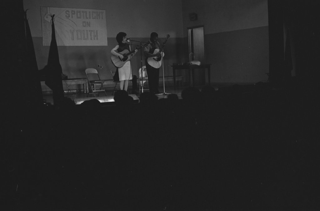 Folk singers performing in a school auditorium - Flerlage, Raeburn, 1915-2002