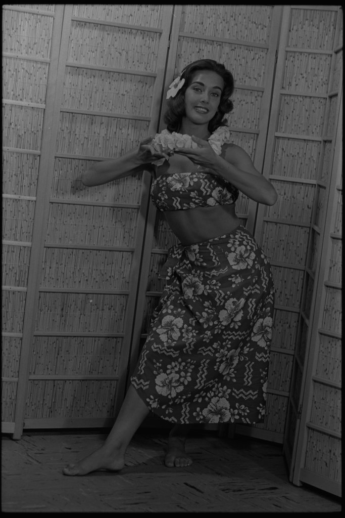 Model posing in a grass hula skirt - Flerlage, Raeburn, 1915-2002