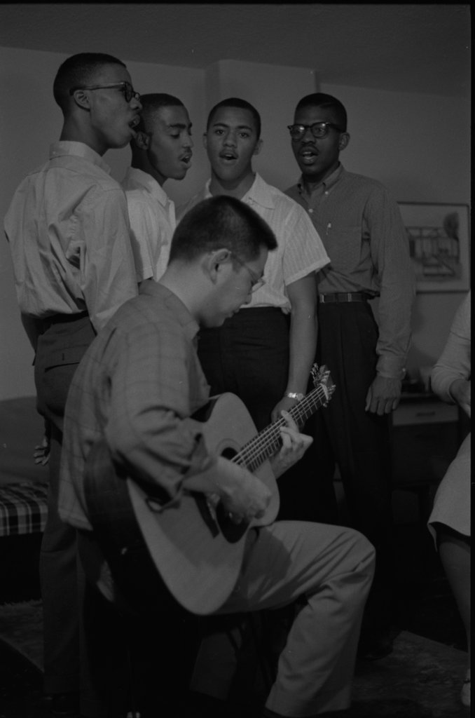 Ella Jenkins signing and playing music with a guitarist and group of four young male vocalists - Flerlage, Raeburn, 1915-2002
