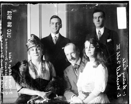 Mr. and Mrs. Maldwin Drummond seated, with her children, Gwendolyn Field, who is sitting, and Marshall Field III, smiling, and Henry Field, standing behind them - Chicago Daily News, Inc.