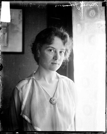 Myrtle Johnson, standing by a window in a room - Chicago Daily News, Inc.