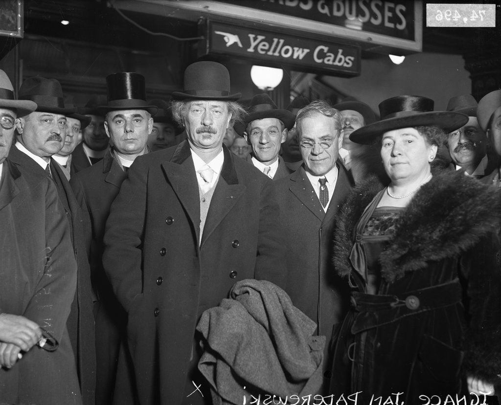 Ignace Jan Paderewski standing with a coat in one hand at the front of a large group of people - Chicago Daily News, Inc.