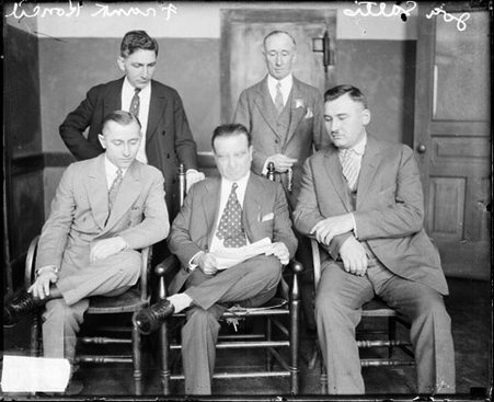 Frank Koncil and reputed gangster Joe Saltis sitting with an unidentified man holding a piece of paper, unidentified man's face is blurred - Chicago Daily News, Inc.