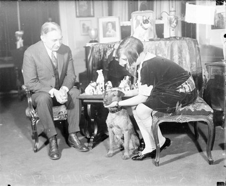 Attorney Edward R. Litsinger sitting with his daughter and a dog in a living room - Chicago Daily News, Inc.