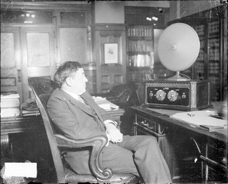U. S. district judge for the Northern District of Illinois, James Herbert Wilkerson, sitting in front of a radio at a desk in an office - Chicago Daily News, Inc.