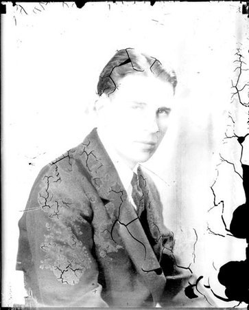 Chicago Daily News worker Bill Stoneman sitting in front of a light-colored backdrop in a room - Chicago Daily News, Inc.