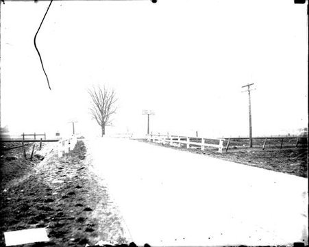 Road crossing Chicago and Northwestern Railway tracks in a rural area - Chicago Daily News, Inc.
